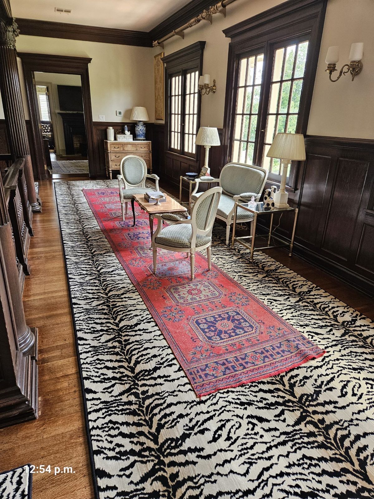 Zebra-pattern custom-cut area rug in a wood-paneled sitting room