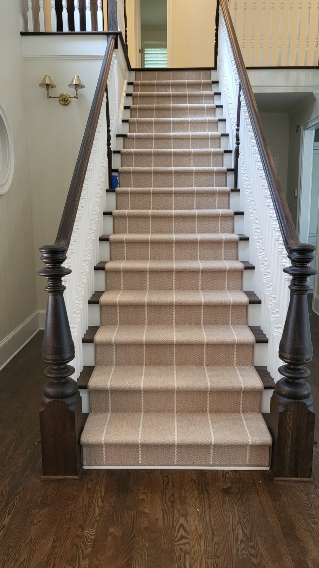 Tan plaid stair runner on traditional staircase with dark balusters