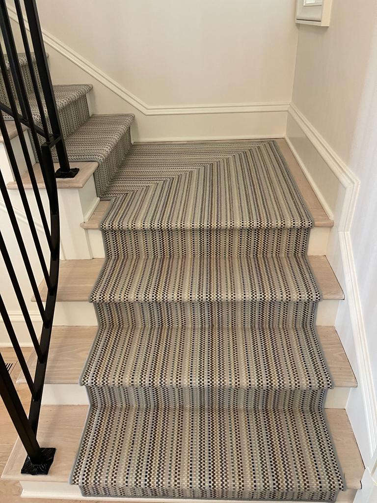 Multicolor striped woven stair runner on light wood stairs