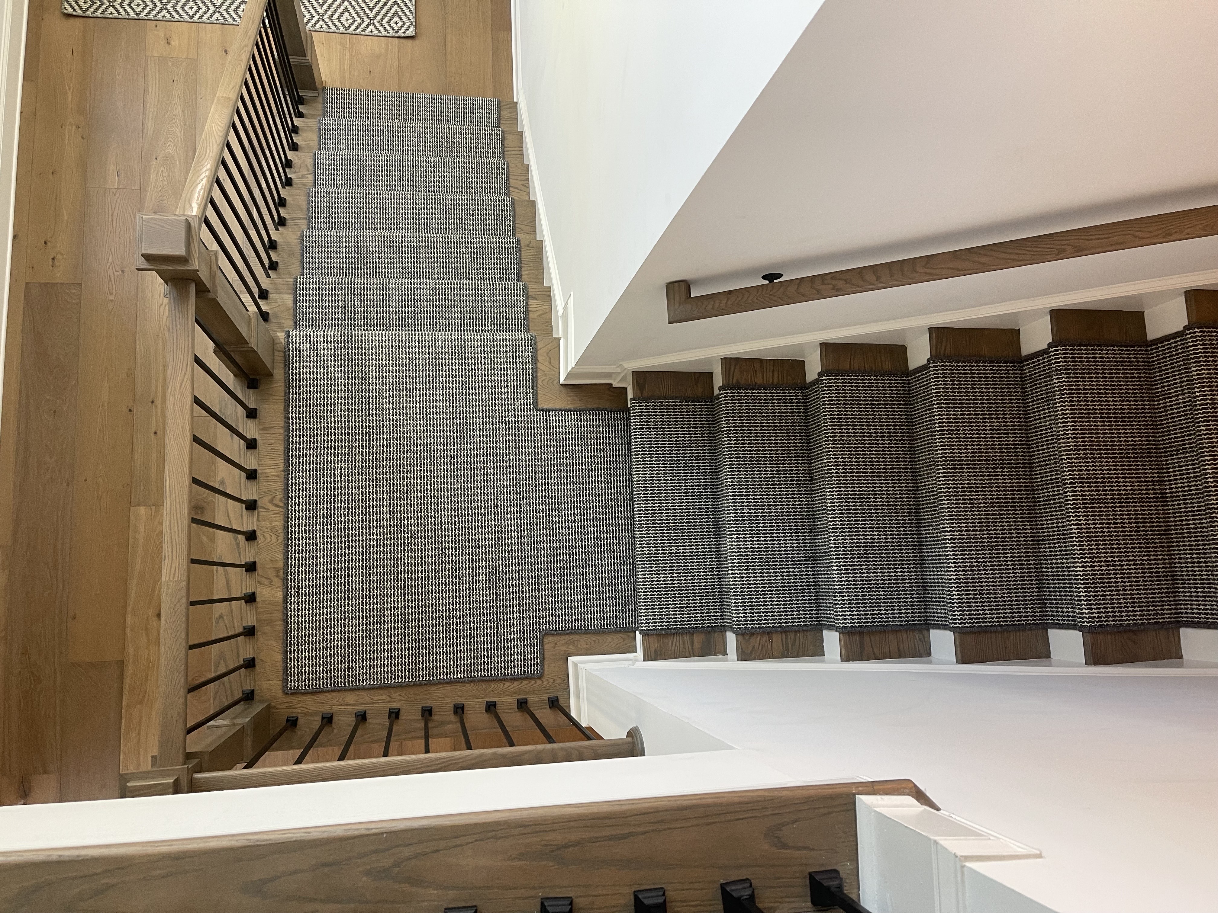 Modern gray woven runner on light wood multi-flight staircase