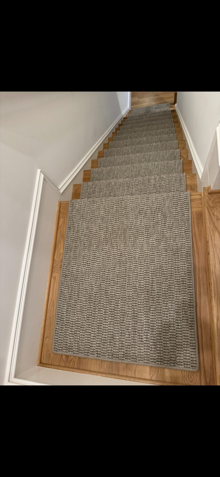 Natural woven sisal hallway runner with bound edges on a hardwood floor