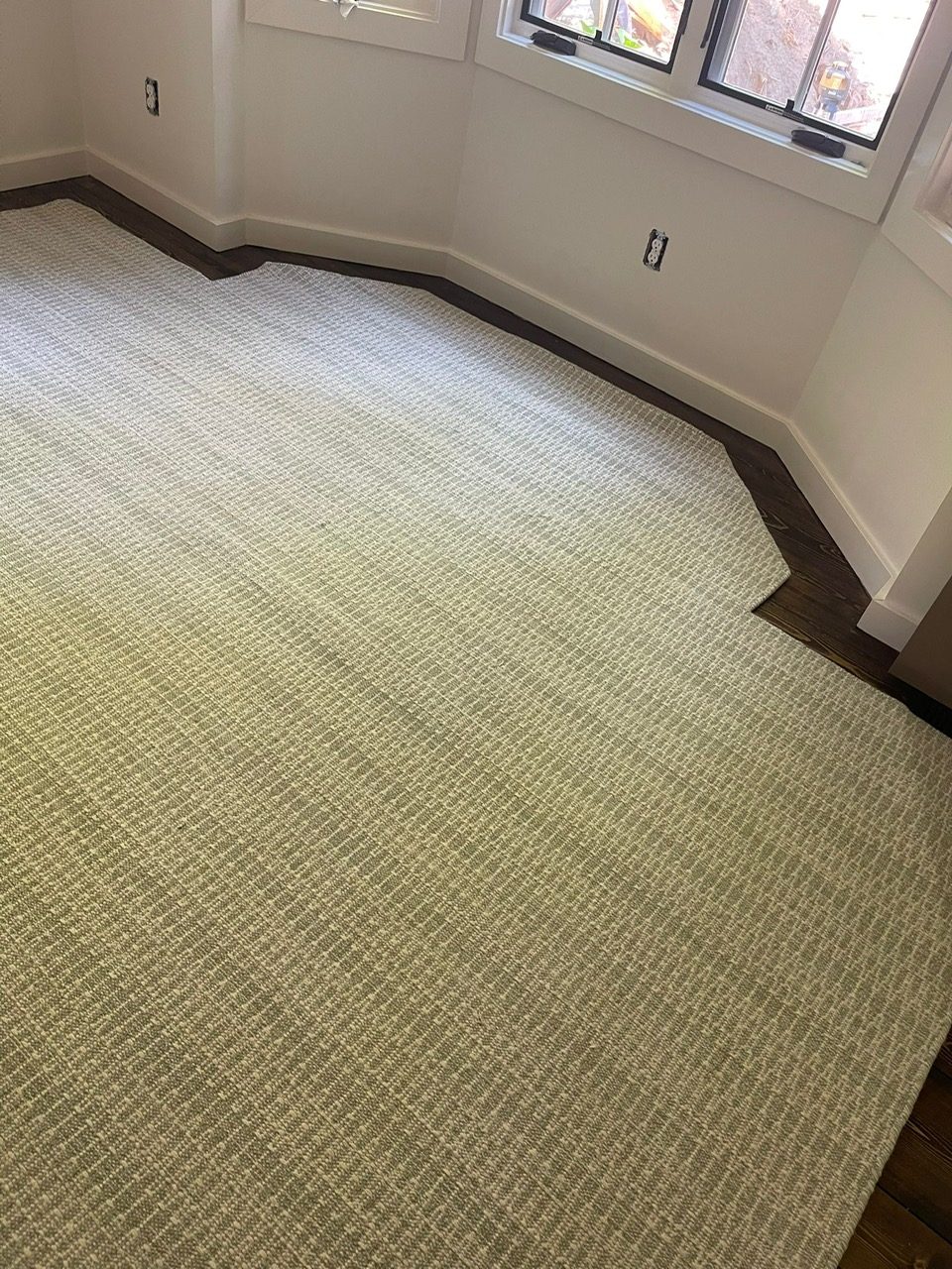 Wall-to-wall natural sisal carpet custom-fit to a bay window room