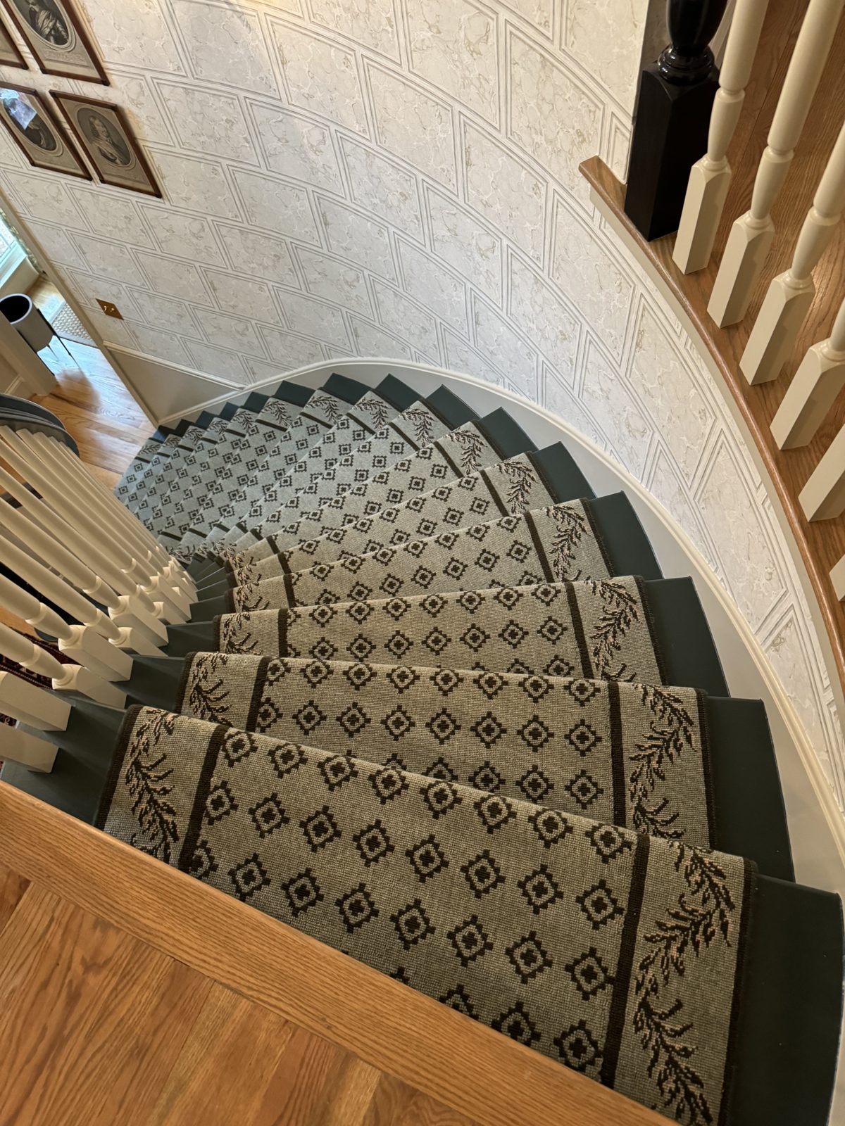 Geometric runner with laurel border on a sweeping curved staircase