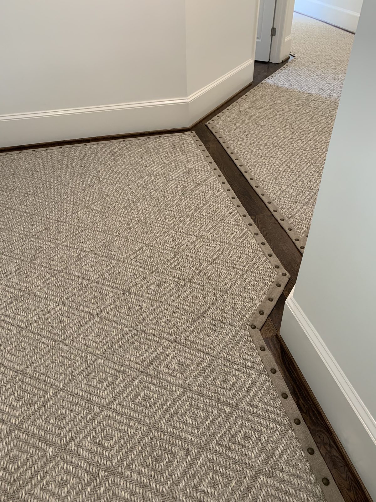 Custom hallway runner with a dark border turning down a hardwood hall