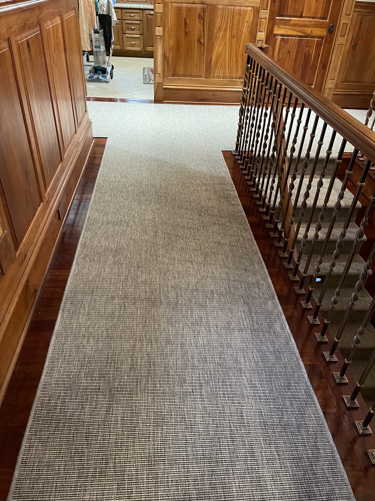 Gray bordered hallway runner on a hardwood landing