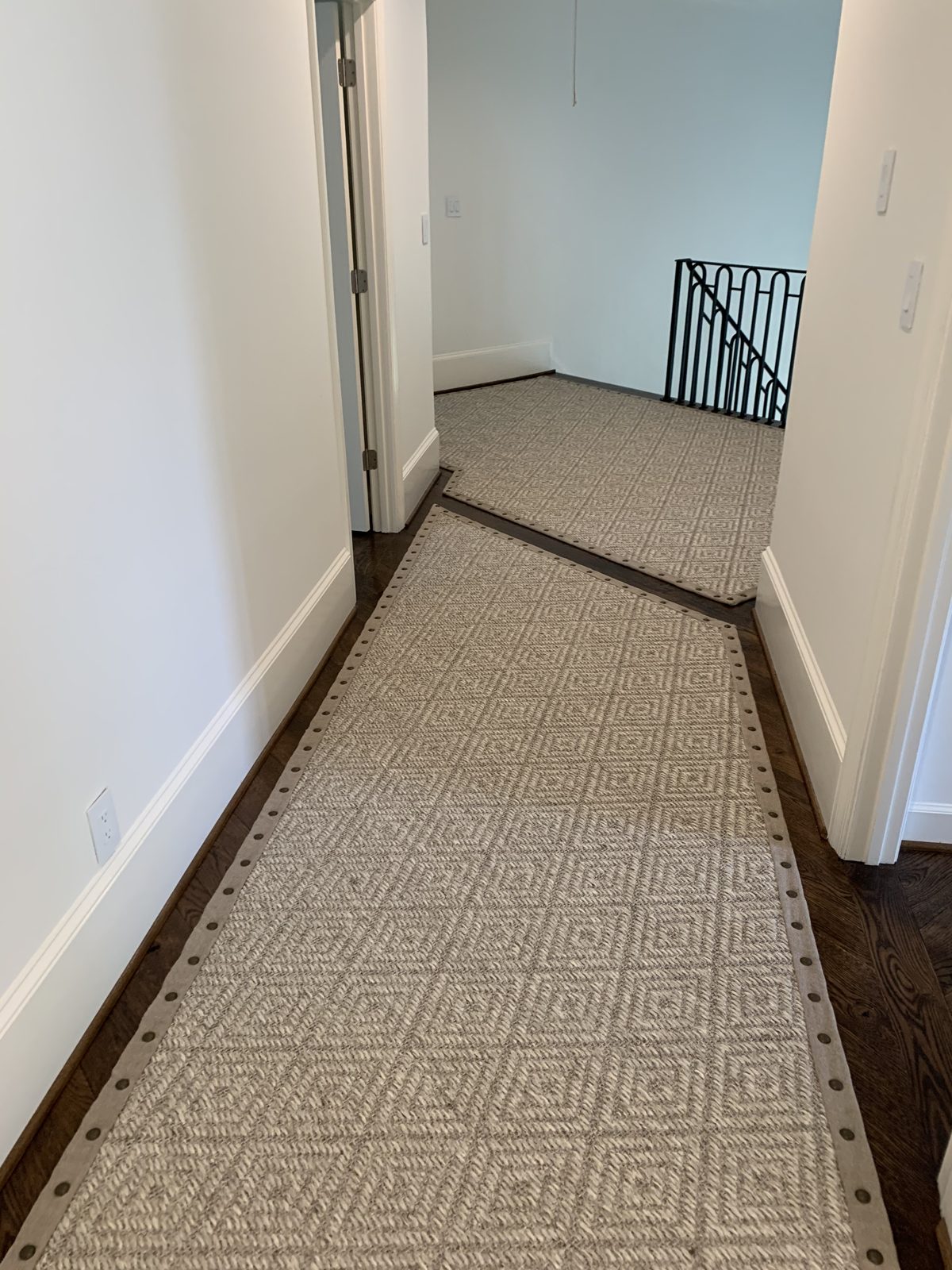 Bordered hallway runner beside a sunlit window