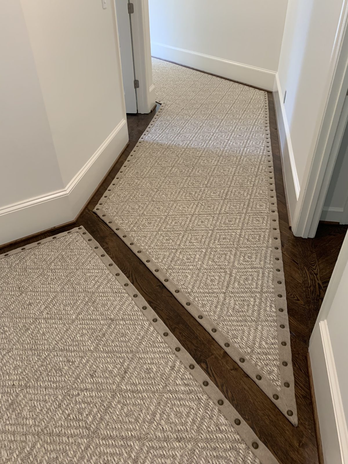 Hallway runner with a bound border and nailhead trim
