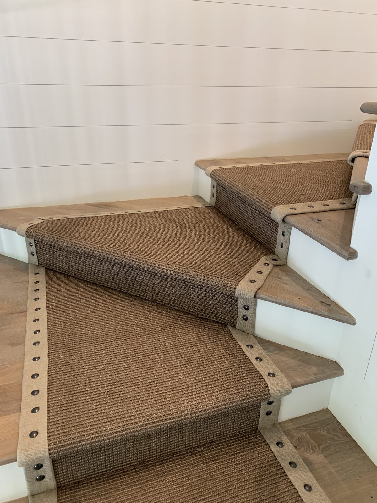 Close-up of a sisal stair runner with a bound leather border