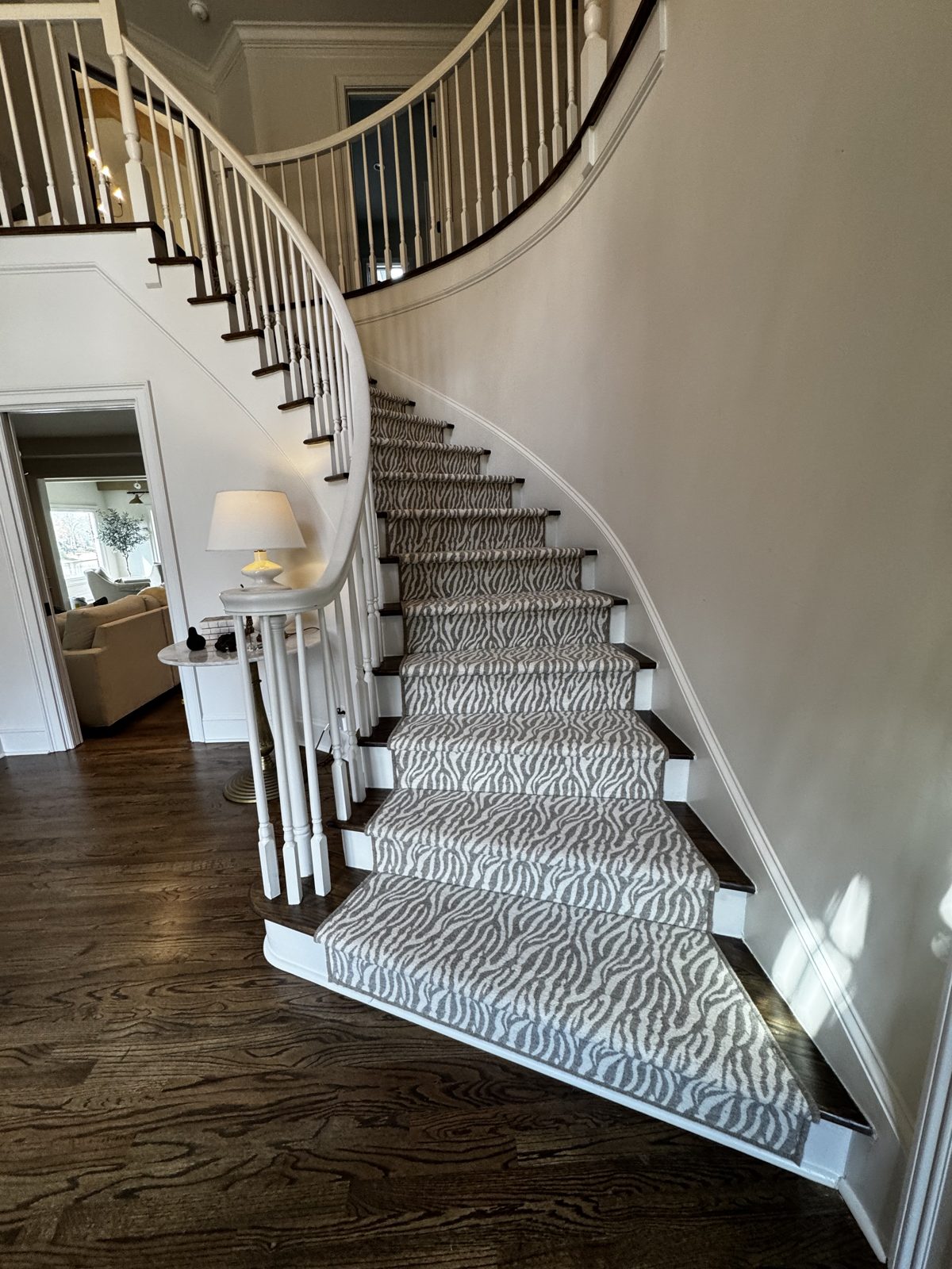 Elegant curved staircase with a striped stair runner