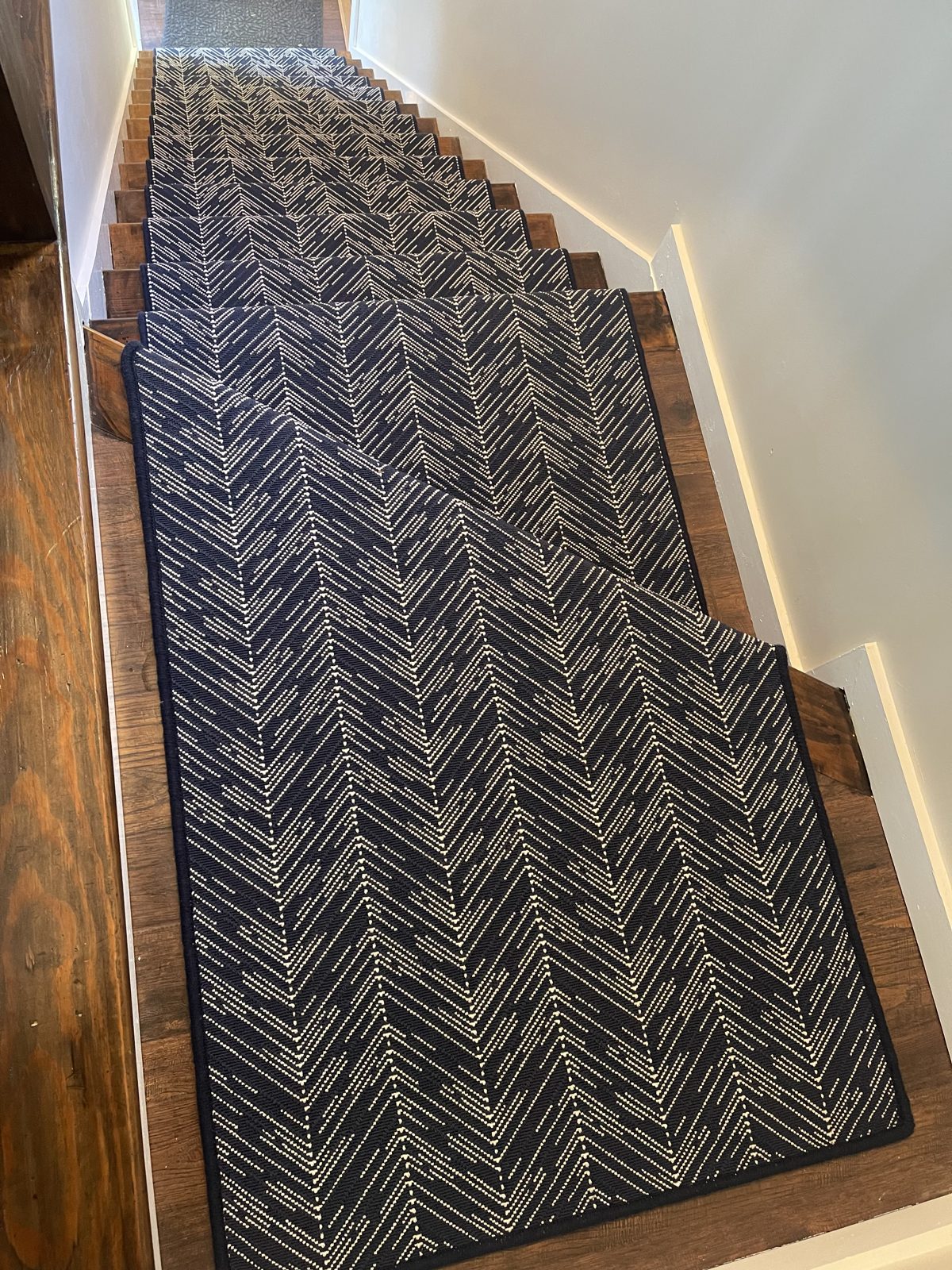 Navy chevron stair runner on a curved staircase