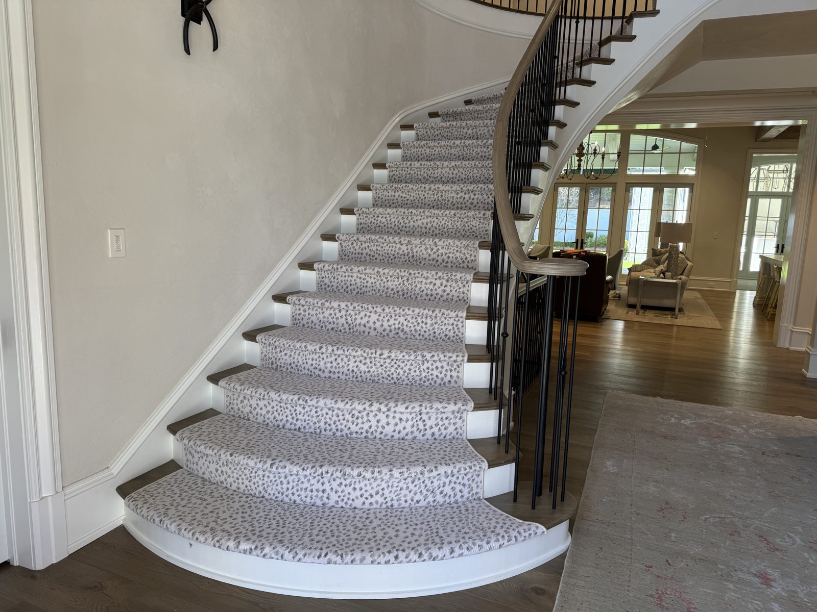 Grand curved staircase with a snow-leopard stair runner