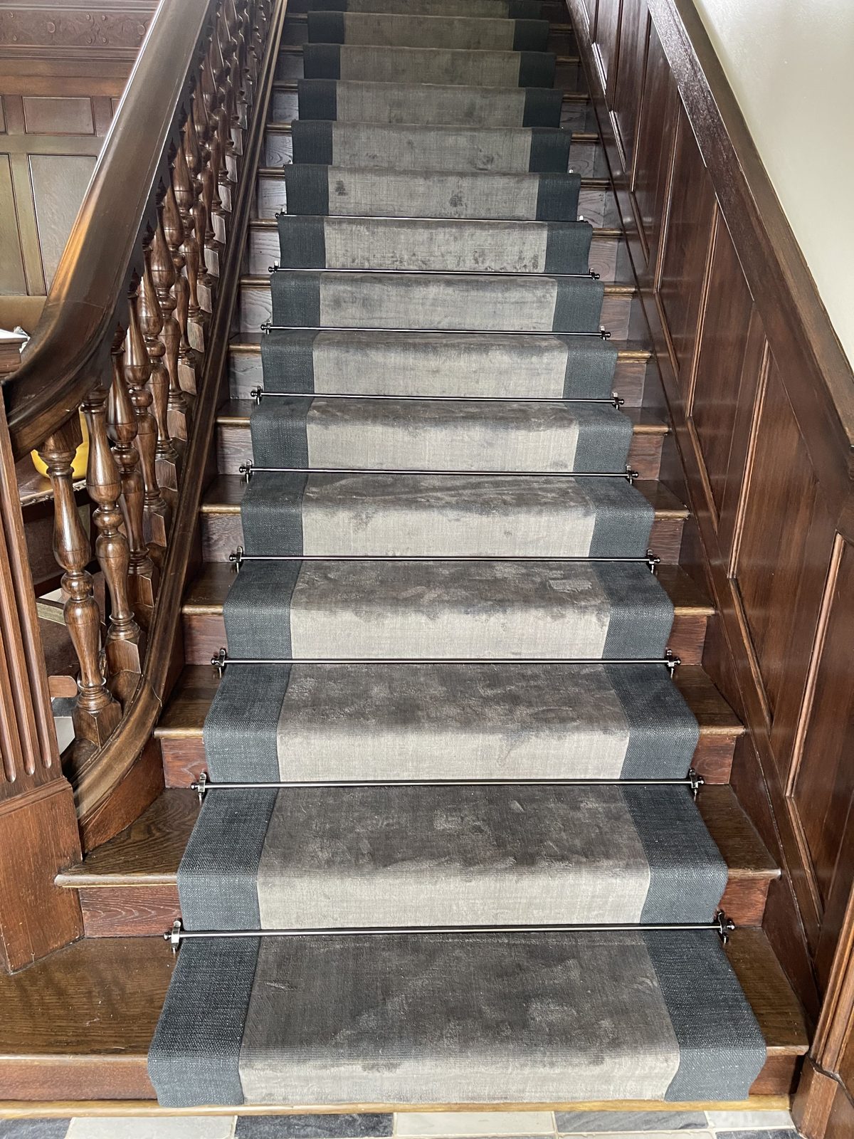 Striped stair runner secured with brass stair rods